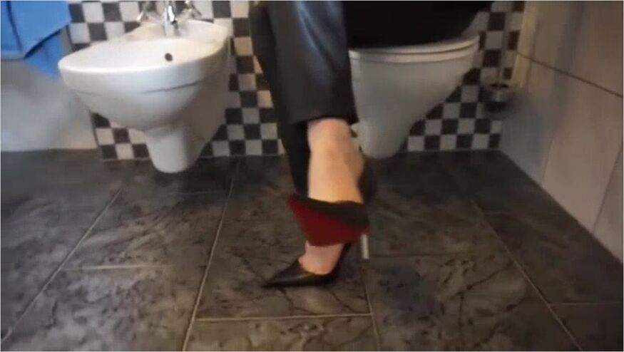 Woman Looks Sexy Wearing Ultra Pointy Stiletto And Leather Pants In The Bathroom